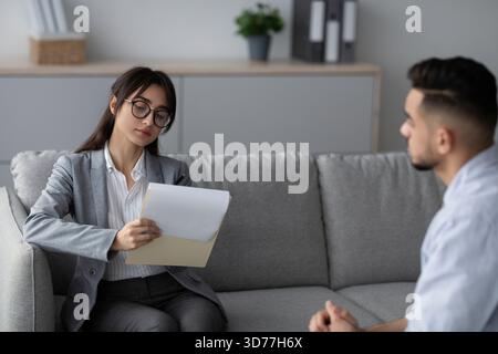Female Psychotherapist Conducts Session With Young Man in a Comfortable Office Setting Stock Photo