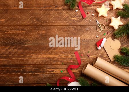 Christmas gift wrapping with star candles, wrapping paper, fir spruces, gift tags on wooden desk. Copy space. Stock Photo