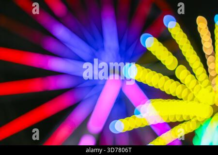 Vibrant abstract bokeh pattern. Dizzying motion blur from carnival lights at night. Funky funfair backdrop. Stock Photo