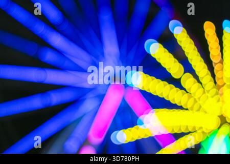 Dynamic blue spiral bokeh formed by Ferris wheel lights at night.A futuristic festival-inspired abstract ideal for digital,motion,creative backgrounds. Stock Photo