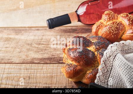 Shabbat Shalom. Bread challah with sesame seeds and poppy seeds on wooden background. Traditional jewish bread for Shabbat and Holidays. Rustic concept. Copy space. Selective focus. Stock Photo