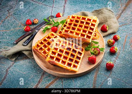 fresh baked homemade Brussels waffles with fresh strawberries on a plate Stock Photo