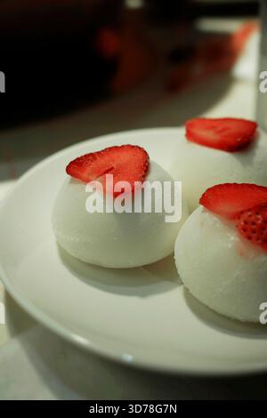Vanilla mochi ice cream decorated with fresh slices of strawberry Stock Photo