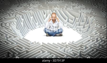 Man lotus position thinking about solution maze labyrinth Stock Photo