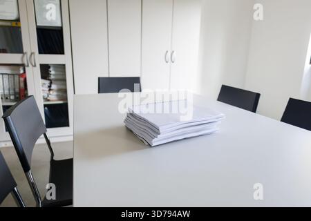 stacked documents on a conference table in a modern office Stock Photo