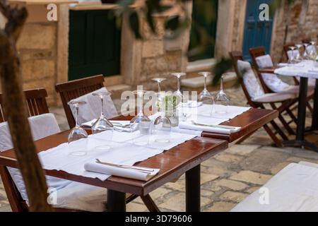 Elegant outdoor dining setting with glassware at a charming Mediterranean restaurant Stock Photo