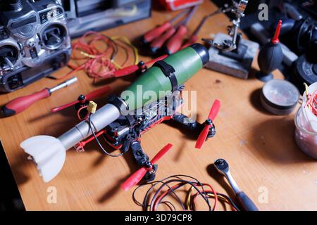 fpv military drone on desk with attached bomb Stock Photo