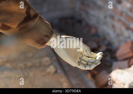soldiers arm with prosthetic hand in ruined building Stock Photo