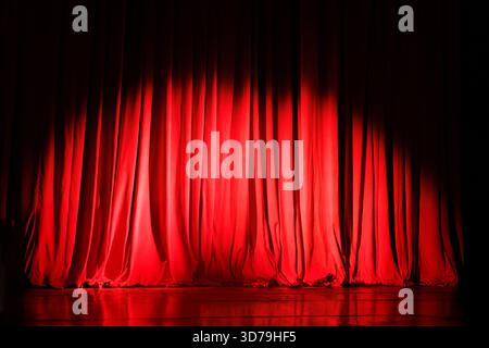 Closed red curtains on theater stage with spotlight Stock Photo