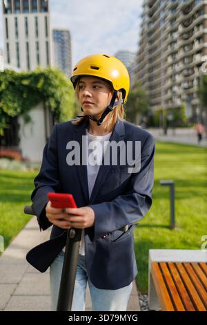 young woman using navigation app while riding an electric scooter Stock Photo