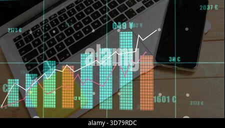 Displaying multicolored financial data visualization over work desk, with laptop and smartphone Stock Photo