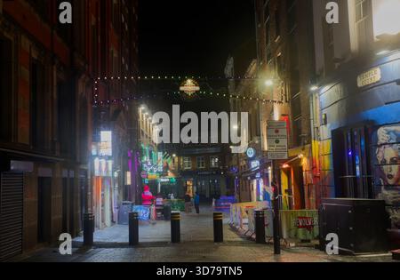 Temple Court, Liverpool's Cavern Quarter, at night. Alleyway street scene with bars, clubs, colourful lights, cobblestones, and decorative lights. Stock Photo