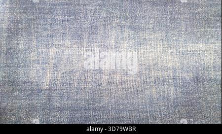 Old stained denim detailed texture of blue jeans fabric. Blue faded denim cotton textile texture background and wallpaper Stock Photo
