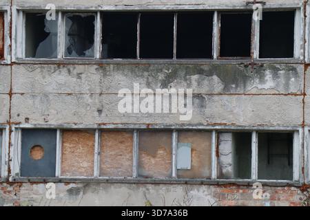 Urban Decay Weathered Facade with Broken and Boarded Windows Stock Photo