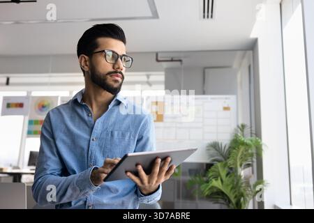 Thoughtful professional man managing online business process on tablet Stock Photo