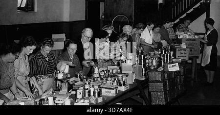 Working Bee at the Baptist church Hurlestone Park packing food parcels for Britain. The food was donated by members of the congregation who either placed food in the special church box or donated money.This is the fifth batch to be sent away and the number of parcels almost two fifty.Breakfast foods, tinned vegs., jam, dripping, sugar, tea, and chewing gum are some of the contents of each part. May 12, 1947. Stock Photo