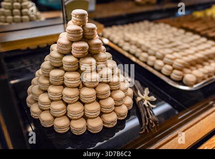 Zurich, Switzerland - November 30, 2024: Rows of small vanilla Luxemburgerli macarons with cream filling on display at Sprungli chocolatier Stock Photo