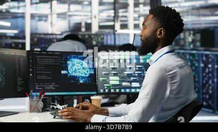 Server hub engineering team interprets AI generated data analytics graphs. Teamworking data center colleagues using artificial intelligence program showing predictive system metrics, camera B Stock Photo