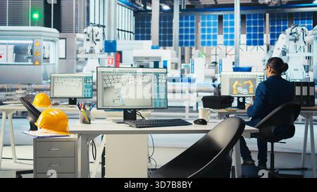 Photovoltaics factory manager working with solar engineering team, doing brainstorming, improving systems reliability. Solar panel manufacturing plant specialist providing feedback to workers Stock Photo