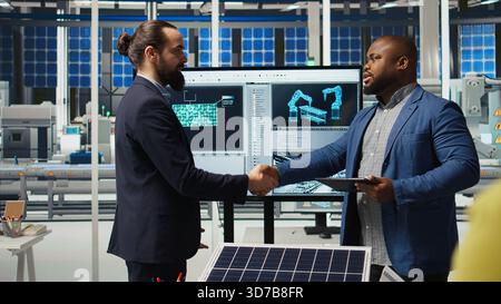Industrial plant engineers discussing ways to refine designs for increased energy output. Factory employees in workspace collaborating on solar cell prototypes on chroma key notebook, camera A Stock Photo