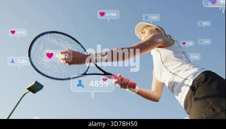 Swinging tennis player holding racket on court wearing visor and tank top showing hearts Stock Photo