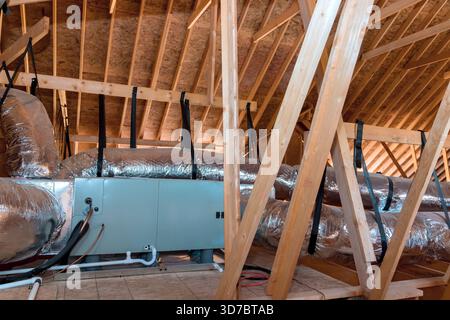 Workers are installing ductwork insulation in attic area of home during renovation. Stock Photo