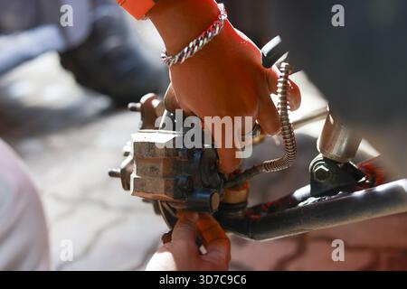 Close up of mechanic hand in focused concentration during an auto repair. worker performs vehicle maintenance and service work on metal brake part in Stock Photo