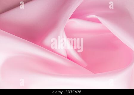 elegant soft pleats of pink silk or satin fabric. Beautifully twisted fabric. Layout for a holiday card, wallpaper Stock Photo