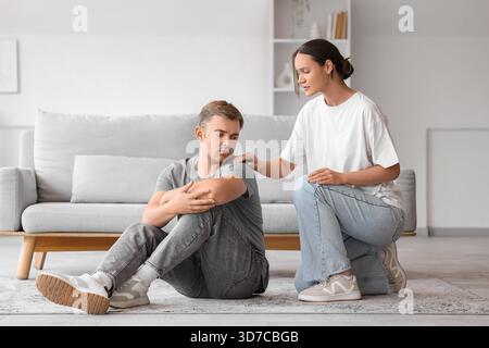 Young woman supporting man with suicidal thoughts at home Stock Photo