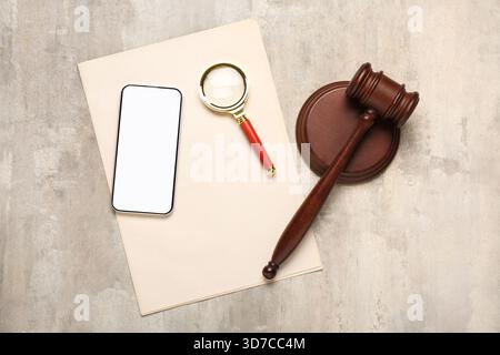 Judge's gavel with mobile phone, magnifier and paper on grunge background Stock Photo