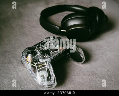 transparent game controller and wireless headphones gaming setup technology Stock Photo