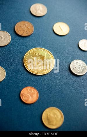 Assorted world coins with a gold bitcoin token in a financial-themed layout Stock Photo