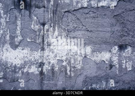 Decayed wall surface with cracks, stains, and weathered textures creating an abstract pattern Stock Photo