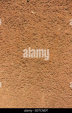 Rough red-brown textured wall surface with coarse, granular detail Stock Photo