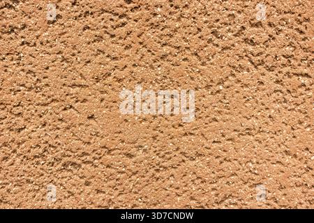 Rough red-brown textured wall surface with coarse, granular detail Stock Photo