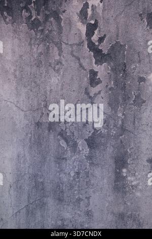 Decayed wall surface with cracks, stains, and weathered textures creating an abstract pattern Stock Photo