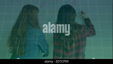 Writing two women working in classroom, marking wall with marker, denim jacket, plaid shirt, grid Stock Photo