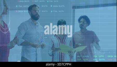 Standing smart team reviewing projected charts on glass in office, holding yellow folder, tablet Stock Photo