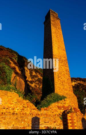 Brick chimney tower at Porth Wen in warm morning light Stock Photo