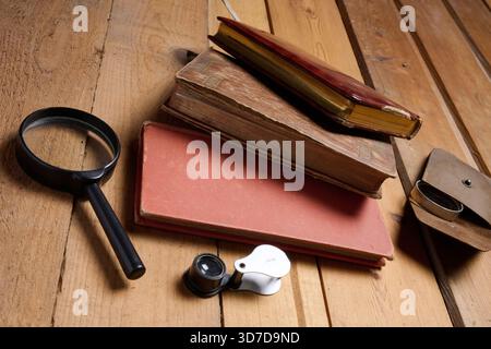 Old prayer books and reading magnifying glasses on wood Stock Photo