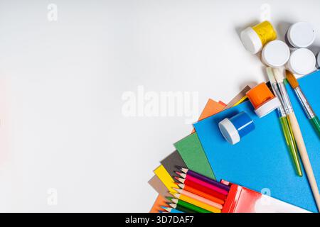 Stationery on a white background with a place for text, colored cardboard, paints, pencils Stock Photo