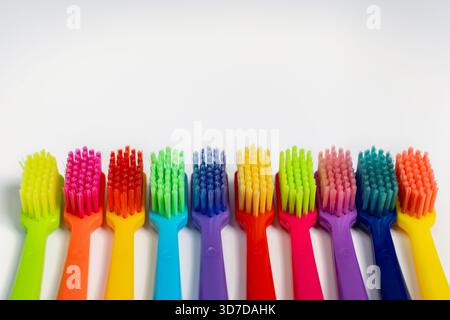 Multicolored toothbrushes lie in a row on a white isolated background Stock Photo