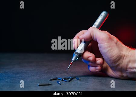 Electric mini screwdriver and several different interchangeable bits. Stock Photo