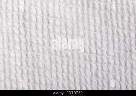 Close up of white waffle weave fabric texture, ideal for backgrounds, textile design, or product presentations. Stock Photo