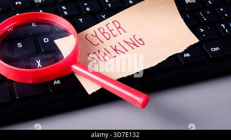 Cyber Stalking Note and Magnifying Glass on Keyboard: Online Crime, Threat, and Internet Security Stock Photo