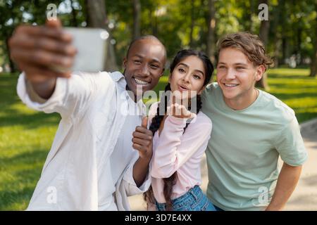 Friends Enjoying a Sunny Day in the Park While Taking a Cheerful Selfie Together Stock Photo
