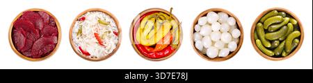 Pickled vegetables in wooden bowls. From left to right beetroot slices, puszta coleslaw, peperoni peppers, pearl onions, and crunchy gherkins. Stock Photo