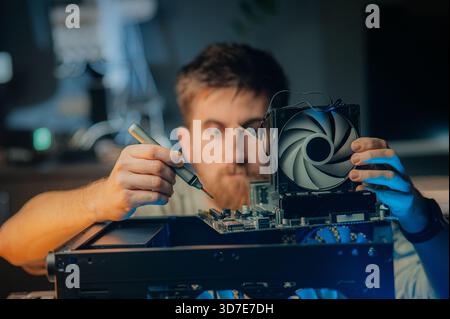 Man assembles a computer system unit at home Stock Photo