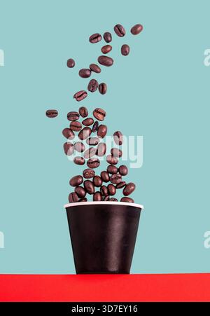 Coffee beans falling in to a paper cup Stock Photo
