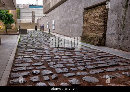 Exposed Roman road with stone paving preserved between museum buildings in Cologne, Germany. Stock Photo